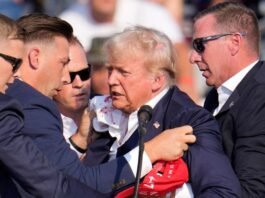 Former US President Donald Trump surrounded by security personnel after the assassination bid