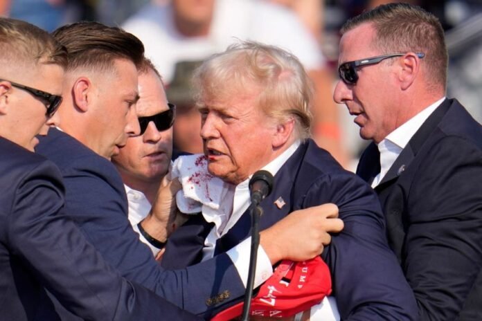 Former US President Donald Trump surrounded by security personnel after the assassination bid